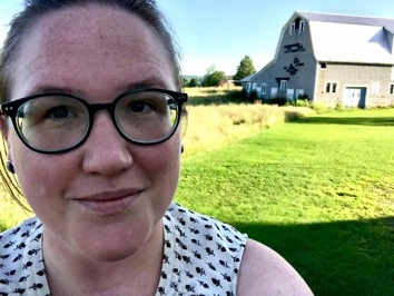Picture of Lauren with sunshine on a farm field and old barn in the background